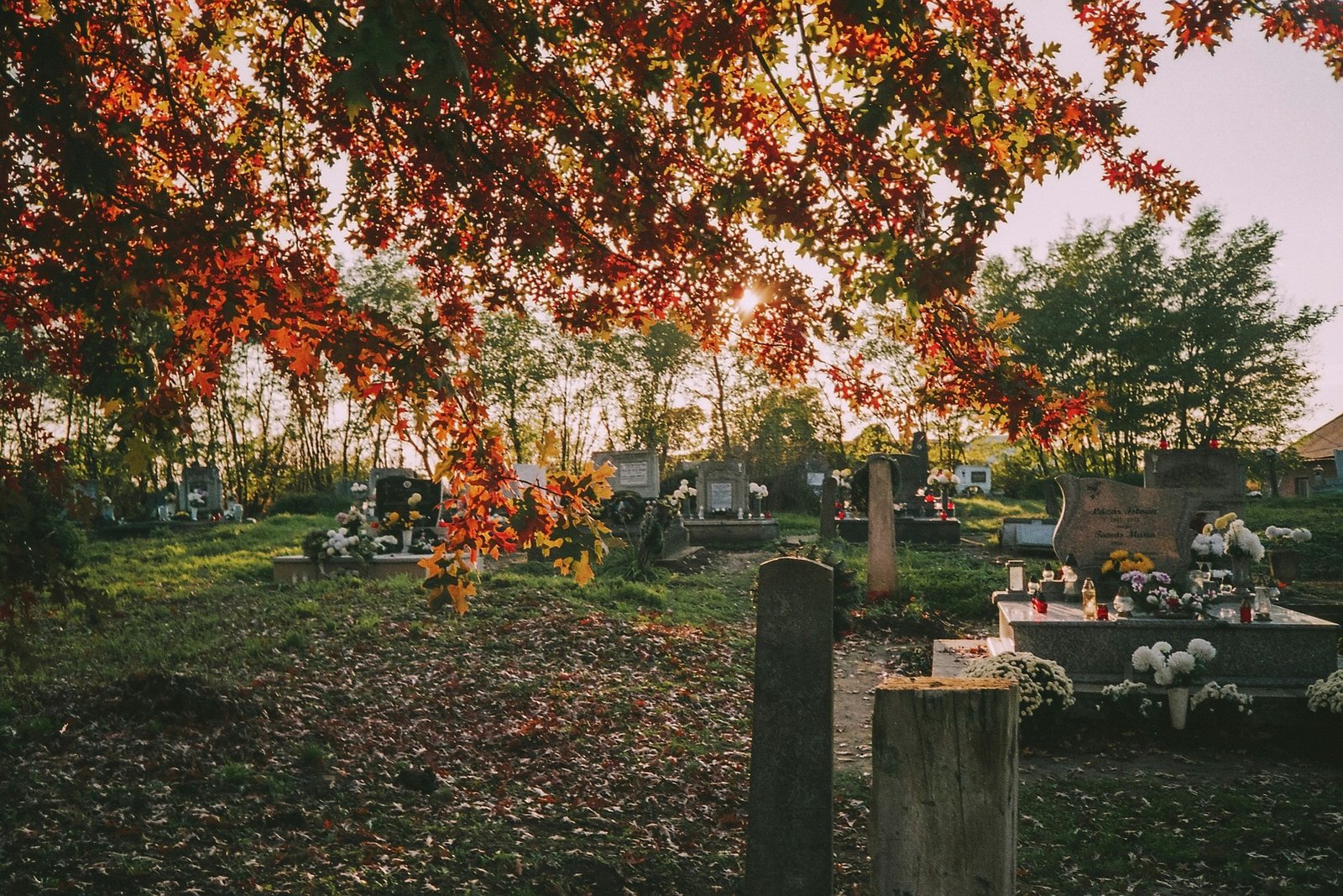 Friedhof im Herbst mit Kerzen und Grabschmuck